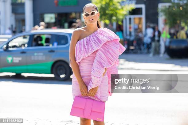 Guest is seen wearing asymmetric pink dress, Jacquemus bag, sandals outside Saks Potts during Copenhagen Fashion Week Spring/Summer 2023 on August...