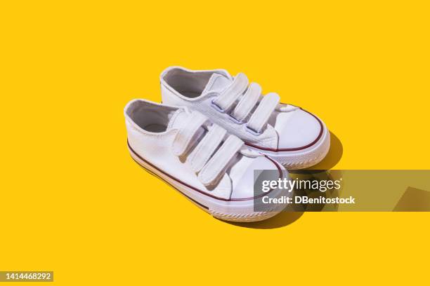 white retro and loop tape sneakers, on a yellow background. fashion, modern, retro, casual footwear concept. - nylon fastening tape stock pictures, royalty-free photos & images
