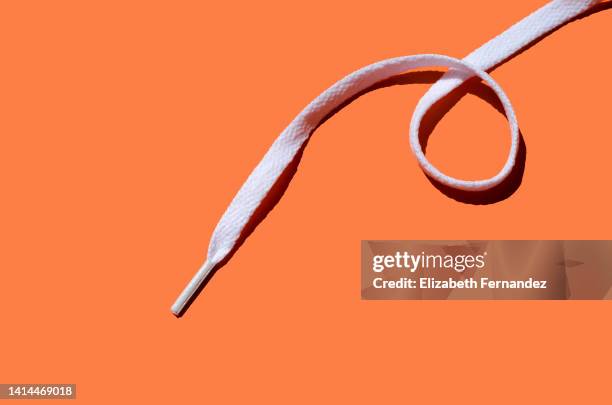 white shoelace on orange background, copy space on image. - shoelaces ストックフォトと画像
