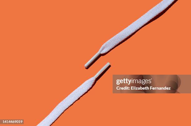 white shoelaces on orange background, copy space on image. - shoelaces ストックフォトと画像