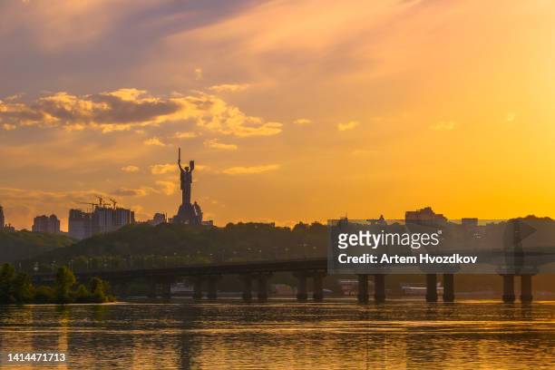 monument of mother motherland. summer cityscape view. vibrant yellow  colored sky - kiev photos et images de collection