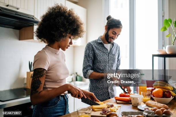 apasionada pareja multiétnica en la cocina preparando comida y divirtiéndose - couples making passionate love fotografías e imágenes de stock