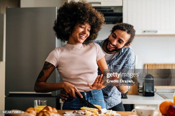 apasionada pareja multiétnica en la cocina preparando comida y divirtiéndose - couples making passionate love fotografías e imágenes de stock