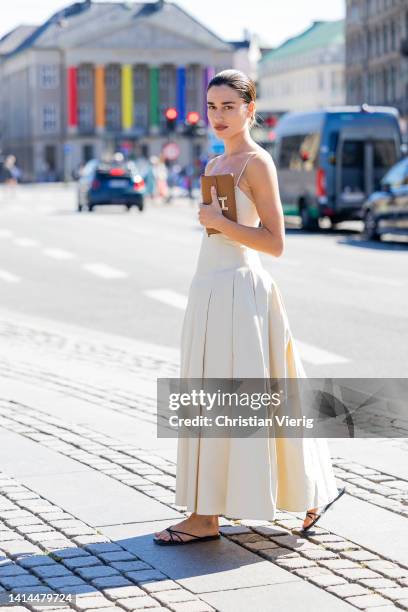 Ilirida Krasniqi is seen wearing creme white dress, brown Hermes c outside Saks Potts during Copenhagen Fashion Week Spring/Summer 2023 on August 11,...