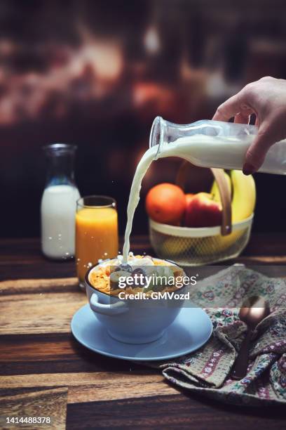 flocos de milho com banana, maçãs e uvas no café da manhã - milk pour - fotografias e filmes do acervo