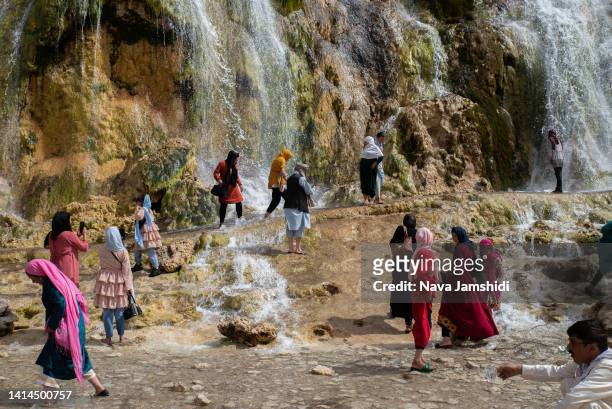 Afghan women walk by a waterfall in the Band-e Amir National Park on August 12, 2022 in Band-e Amir, Afghanistan. The collapse of the economy and the...
