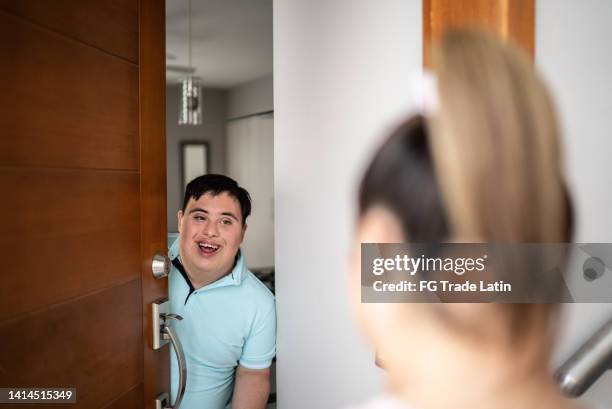 special needs boy open front door and greeting girlfriend at home - surprise guest stock pictures, royalty-free photos & images