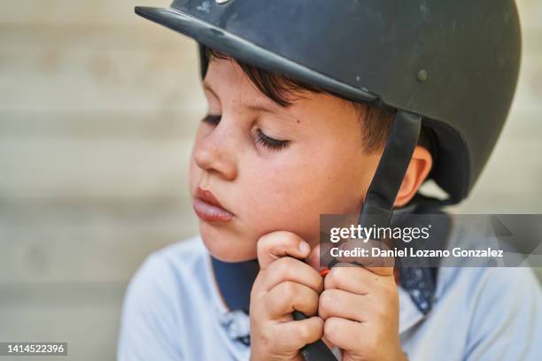 boy taking off protective equestrian helmet - hobby horse stock pictures, royalty-free photos & images