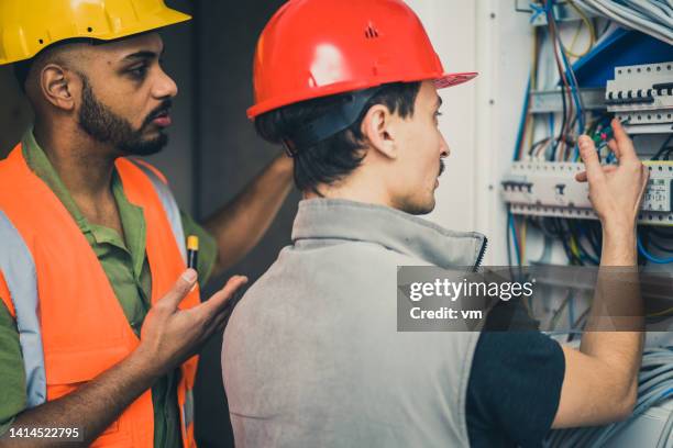 electricians inspecting and testing new electrical switchboard - electrical switchboard stock pictures, royalty-free photos & images