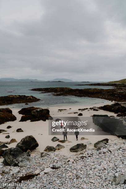 friends explore white sand beaches and rocky shoreline - scottish coat stock pictures, royalty-free photos & images