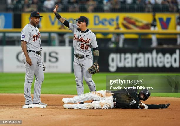 Luis Robert of the Chicago White Sox grimaces after suffering a wrist injury while trying to steal second base against the Detroit Tigers at...