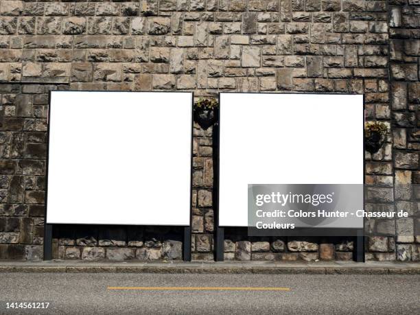 two white and empty advertising panels on a old stone wall and empty street in montreux, switzerland - poster wall stock-fotos und bilder