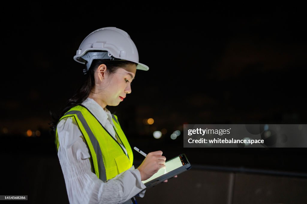 Asian engineers woman work late at night.