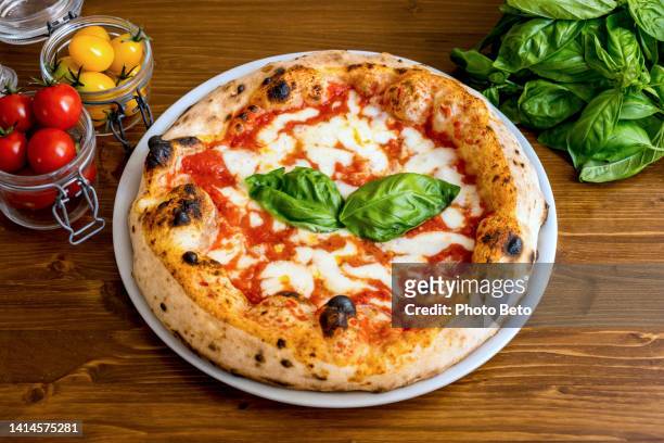 a delicious and tasty italian pizza margherita with tomatoes and buffalo mozzarella - pizzeria stockfoto's en -beelden