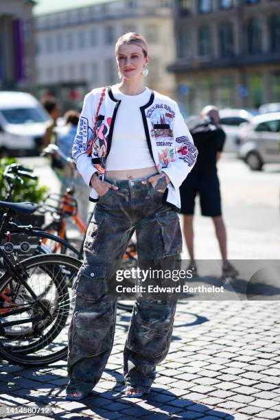 Marianne Theodorsen wears pearls pendant earrings, a white ribbed cropped t-shirt, a white with blue / pink / black Minnie & Mickey print pattern...