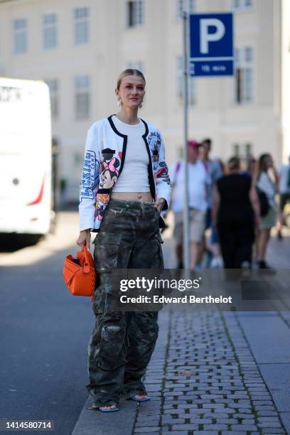 Marianne Theodorsen wears pearls pendant earrings, a white ribbed cropped t-shirt, a white with blue / pink / black Minnie & Mickey print pattern...