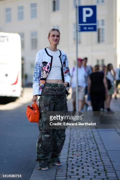 Marianne Theodorsen wears pearls pendant earrings, a white ribbed cropped t-shirt, a white with blue / pink / black Minnie & Mickey print pattern...