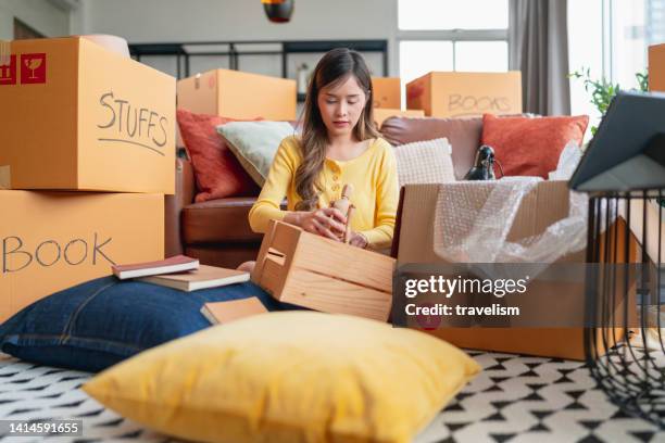 happiness young adult asian female woman packing things into boxes prepare moving from old place to new home with cheerful and happiness,home moving house booming ideas concept - decluttering stock pictures, royalty-free photos & images