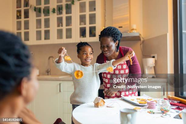 mother making christmas gingerbread cookies with daughter - old man woman christmas stockfoto's en -beelden
