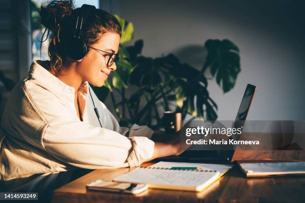 young woman using laptop at home. - educazione online foto e immagini stock