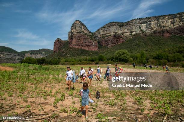 Visitors walk to the 11th-century church, visible due to the drought in the Sau reservoir, currently at 37% capacity on August 13, 2022 in Vilanova...