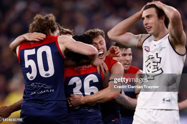 Melbourne players jump on team mate Kysaiah Pickett after he kicked a gaol as Caleb Marchbank of the Blues looks on during the round 22 AFL match...