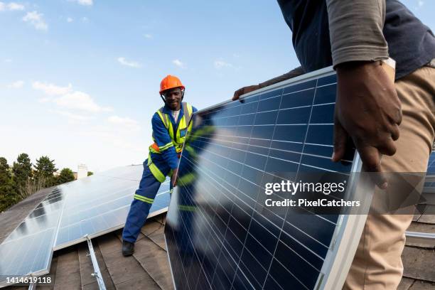 close up solar panel being unloaded on roof - solar panel installation stock pictures, royalty-free photos & images