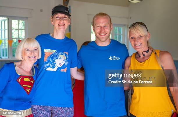 Jonnie Peacock poses with runners during The National Lottery Park Run at Heaton Park on August 13, 2022 in Manchester, England.