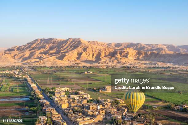 hot air balloon flying over the theban necropolis, luxor, egypt - valley of the queens stock pictures, royalty-free photos & images