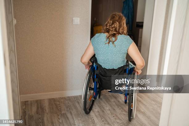 girl with cerebral palsy in a wheelchair moves to a room at home - haciendo burla fotografías e imágenes de stock