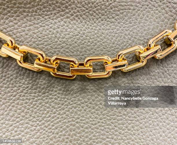 textured leather like material with a decorative metal chain - gold purse chain stock pictures, royalty-free photos & images