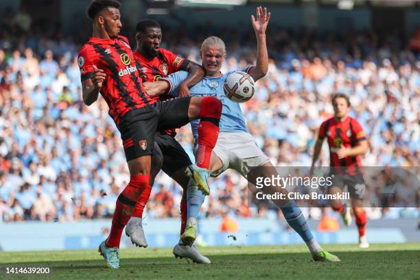 Erling Haaland of Manchester City is challenged by Jefferson Lerma and Lloyd Kelly of AFC Bournemouth during the Premier League match between...