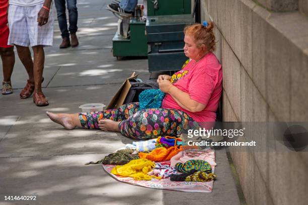 woman sitting on the sidewalk and selling knitwear - senior full body isolated stock pictures, royalty-free photos & images