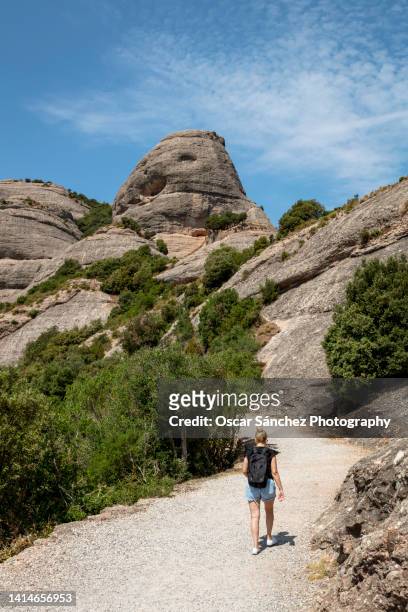 young woman walking on the trails of the montserrat mountains - monte montserrat catalogna foto e immagini stock