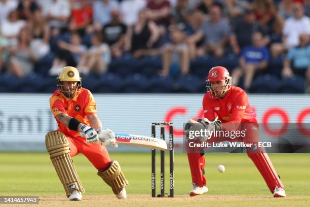 Matthew Wade of Birmingham Phoenix plays a reverse sweep as Joe Clarke of Welsh Fire looks on during The Hundred match between Welsh Fire Men v...