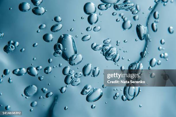 close up macro aloe vera gel serum cosmetic texture blue background with bubbles. - oil macro stock pictures, royalty-free photos & images