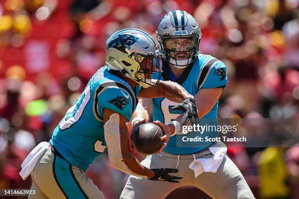 Baker Mayfield of the Carolina Panthers hands the ball off to Chuba Hubbard against the Washington Commanders during the first half of the preseason...