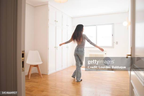 young woman in an empty apartment looking around - mirar alrededor fotografías e imágenes de stock
