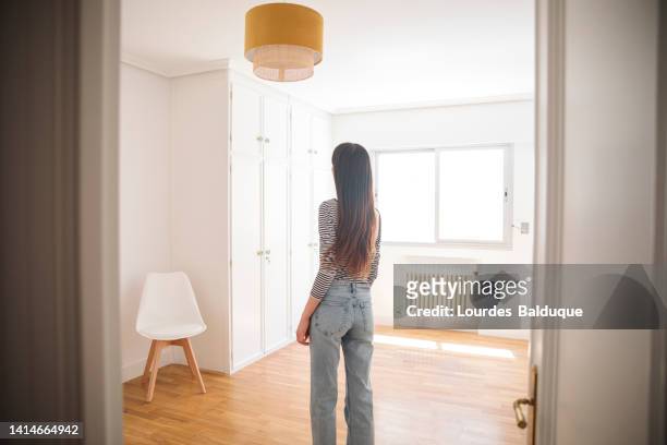 young woman in an empty apartment looking around - women wearing nothing stock pictures, royalty-free photos & images