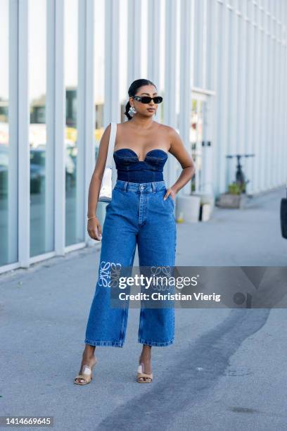 Guest is seen wearing Loewe denim jeans, cropped denim top, silver Prada bag outside Munthe during Copenhagen Fashion Week Spring/Summer 2023 on...