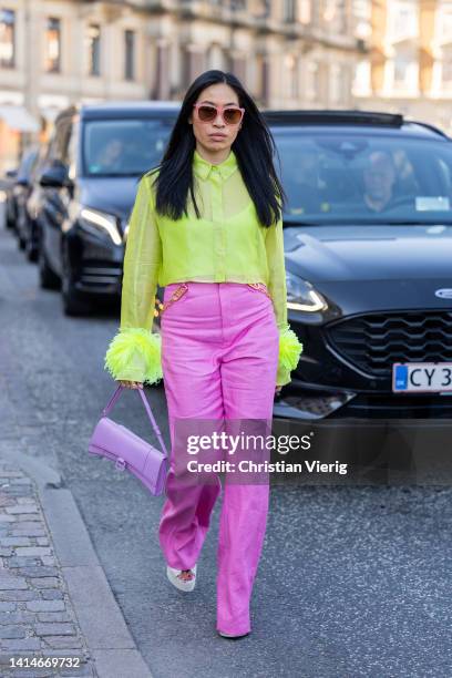 Miki Cheung seen wearing pink pants, neon blouse, purple Balenciaga bag outside Saks Potts during Copenhagen Fashion Week Spring/Summer 2023 on...