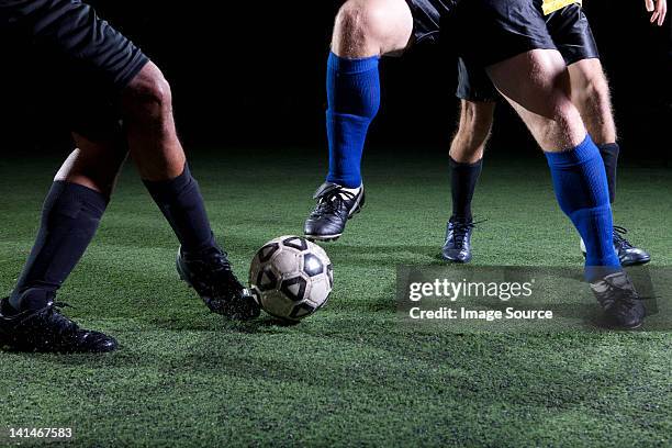 soccer players tackling on pitch, low section - football tackling stock pictures, royalty-free photos & images