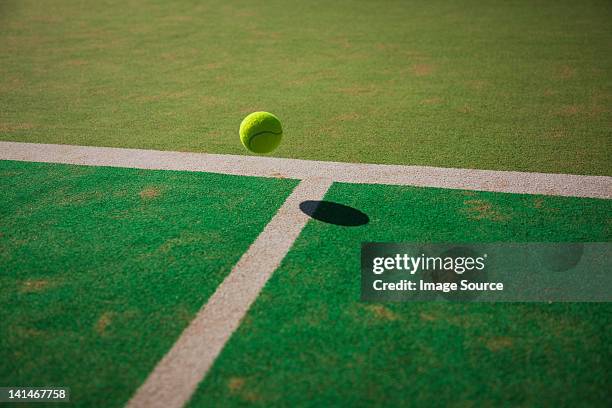 tennis ball bouncing on court - tennis ball stock-fotos und bilder