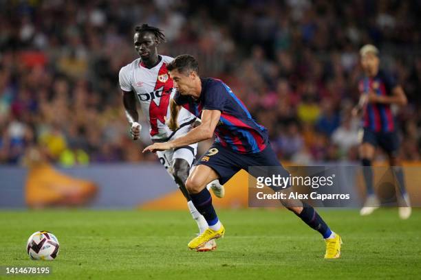 Robert Lewandowski of FC Barcelona is challenged by Pathe Ciss of Rayo Vallecano during the LaLiga Santander match between FC Barcelona and Rayo...