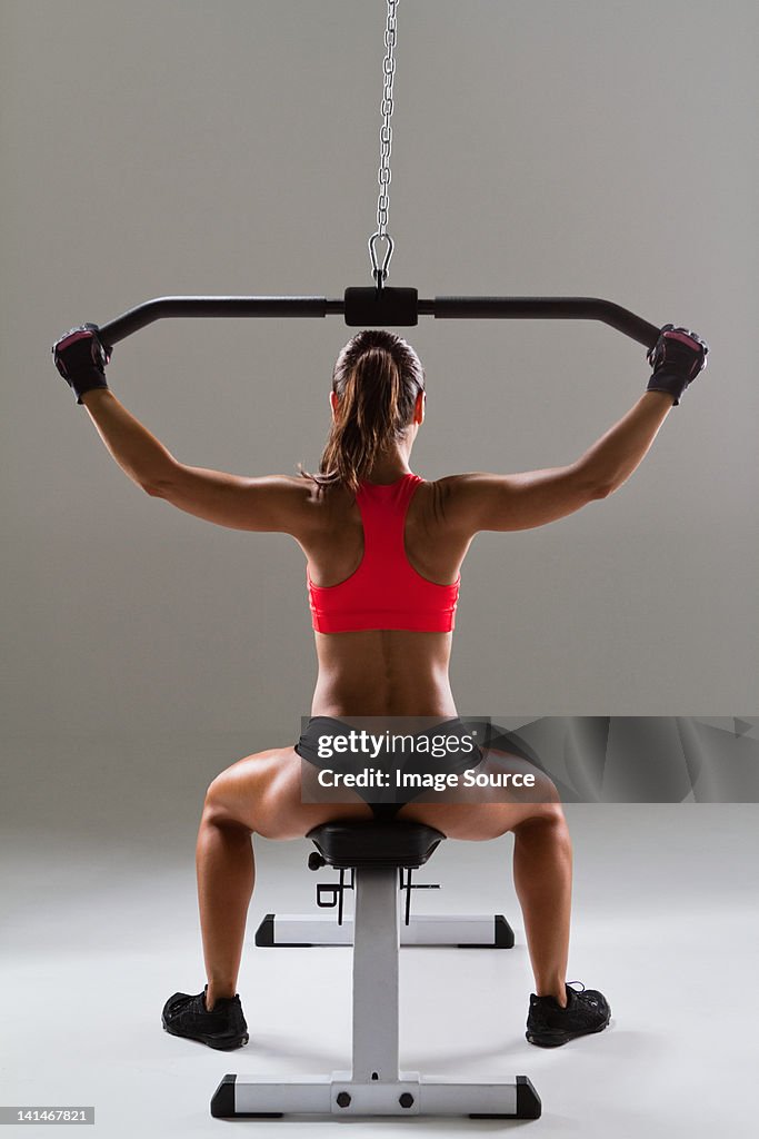 Female weightlifter using weight machine