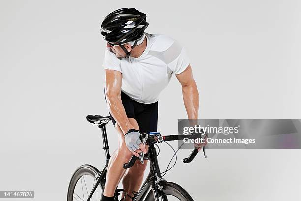 male cyclist looking over shoulder - regarder par dessus son épaule photos et images de collection