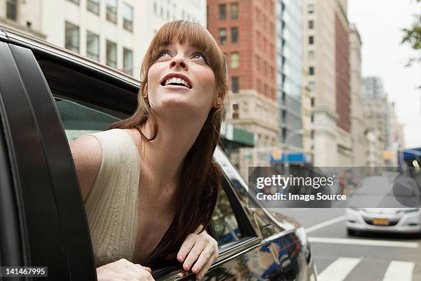 young woman leaning out of taxicab window, looking up - staat new york bildbanksfoton och bilder