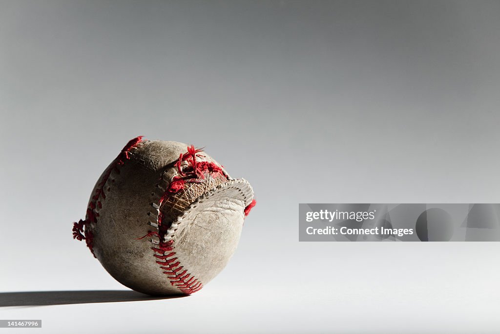 Worn baseball with broken stitching
