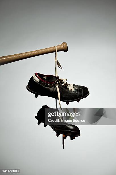 shoes hanging from baseball bat - baseball cleats fotografías e imágenes de stock