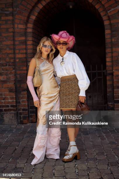 Laura Tønder wearing pink cargo pants, golden silk dress, pink gloves and beige bag and Emma Fridsell wearing white shirt, beige Munthe mini skirt,...